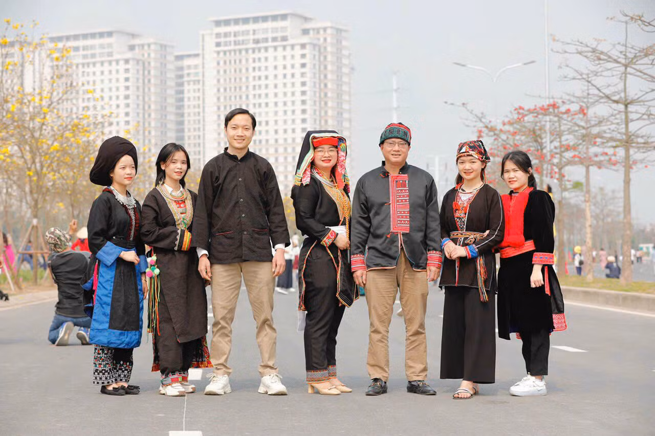 Huyền Trang cùng diện trang phục truyền thống dân tộc Dao bên cạnh các nhánh Dao khác tại vườn hoa Phong Linh, Hà Đông.