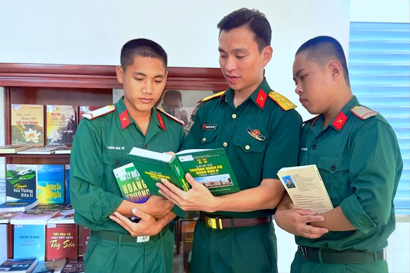 Thượng úy Nguyễn Viết Anh Tuấn (đứng giữa) bên “Tủ sách quân nhân” ở đơn vị