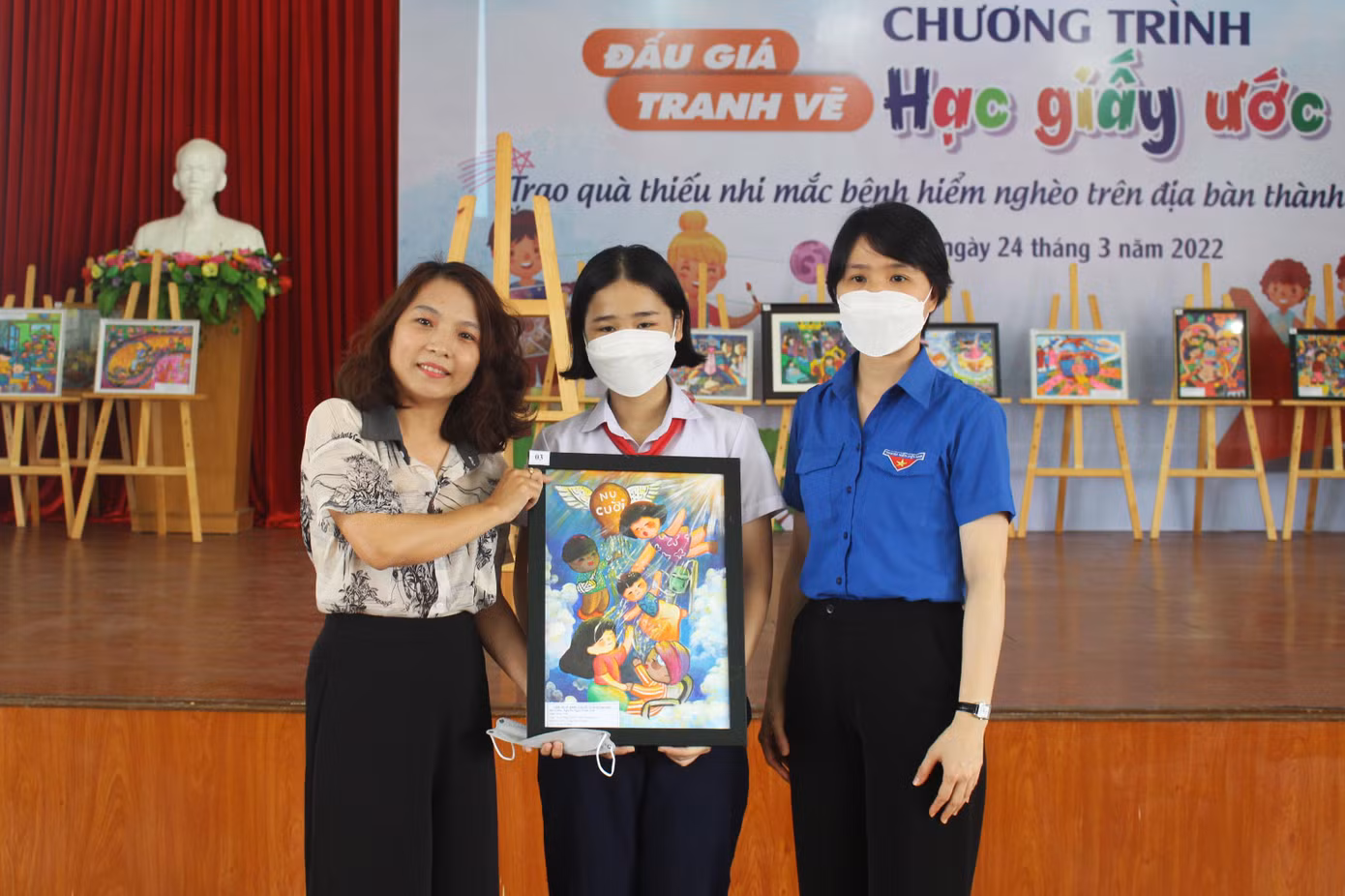 Chị Nguyễn Uyên Thao nhận bức tranh Nụ cười từ tay tác giả Nguyễn Ngọc Trâm Anh, chị đã đấu giá bức tranh này với giá 5,5 triệu đồng