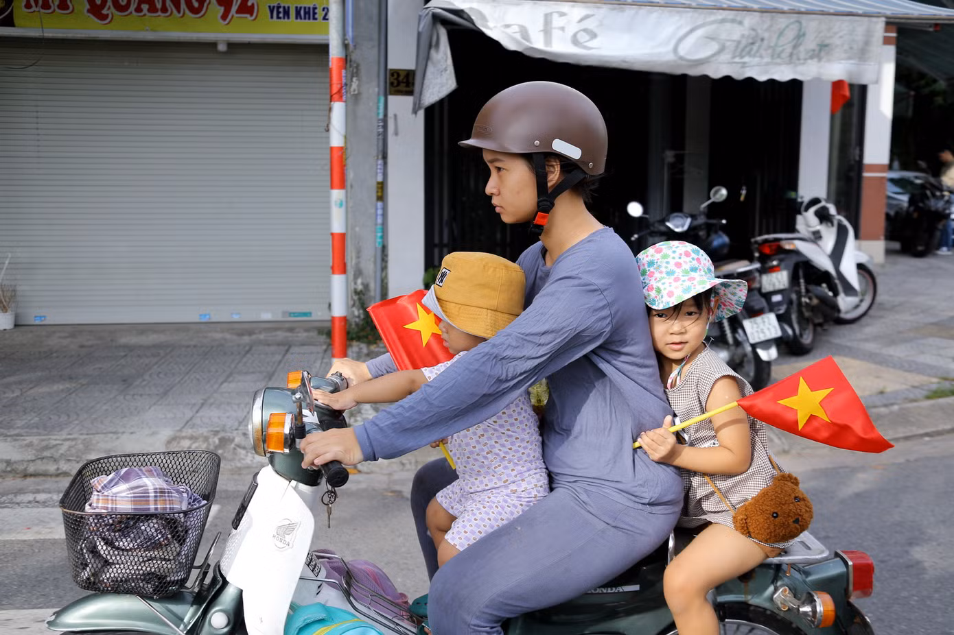 Hai em nhỏ vẫy cờ Tổ quốc trên tay thu hút sự chú ý của nhiều người đi đường.