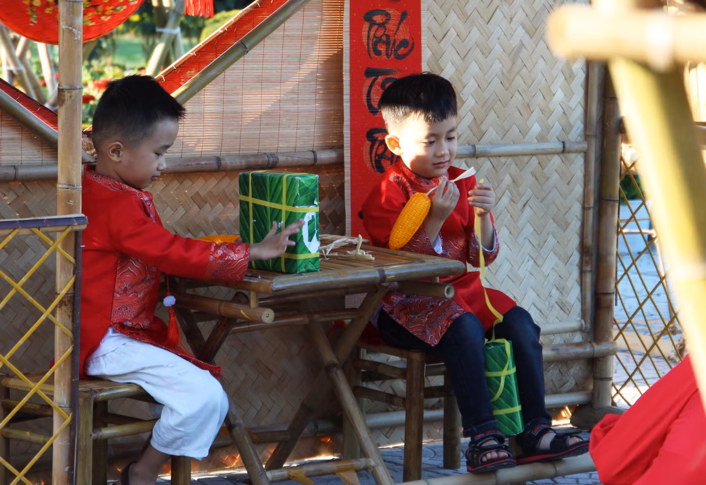 Những tiểu cảnh được trang trí ngập sắc Xuân truyền thống với bánh chưng xanh, câu đối đỏ... được các em nhỏ yêu thích. Nhiều gia đình đưa con đến chụp ảnh trong trang phục áo dài để lưu lại những khoảnh khắc rực rỡ chào năm mới.