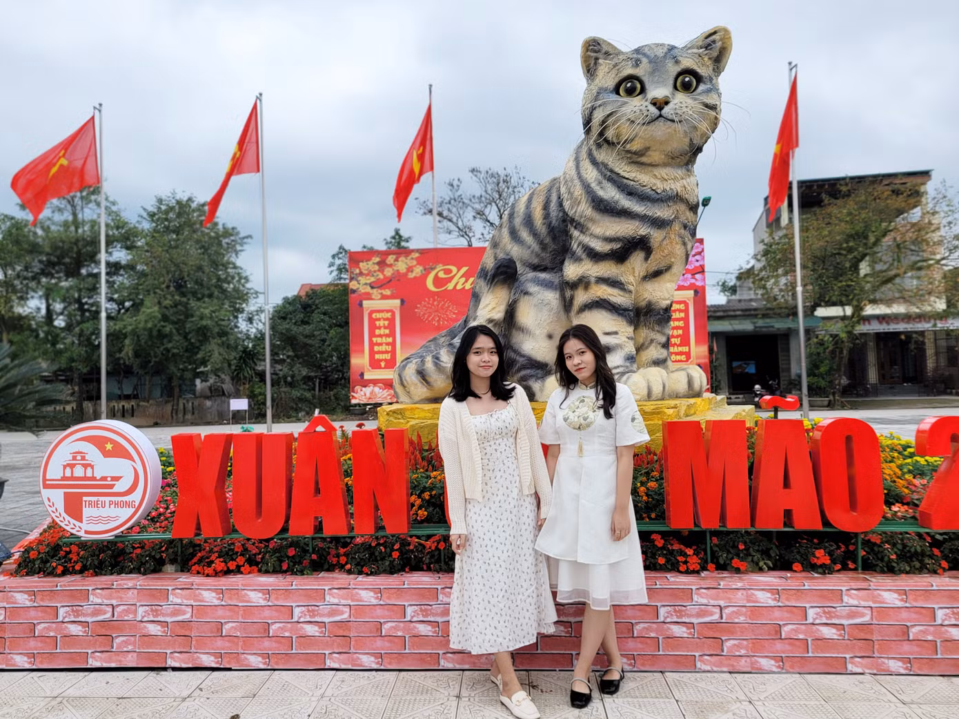 Đi hơn 10km từ TP Đông Hà đến TT Ái Tử để tận mắt chiêm ngưỡng hoa hậu của làng linh vật mèo năm nay, Lê Thị Kim Ngân và Nguyễn Thị Minh Châu (SN 2004) thích thú tạo dáng bên cạnh chú mèo dễ thương này. Ảnh: Giang Thanh