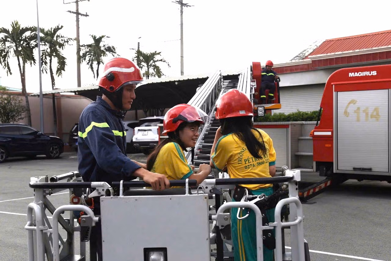 Các em học sinh trải nghiệm trên xe thang cứu hỏa.