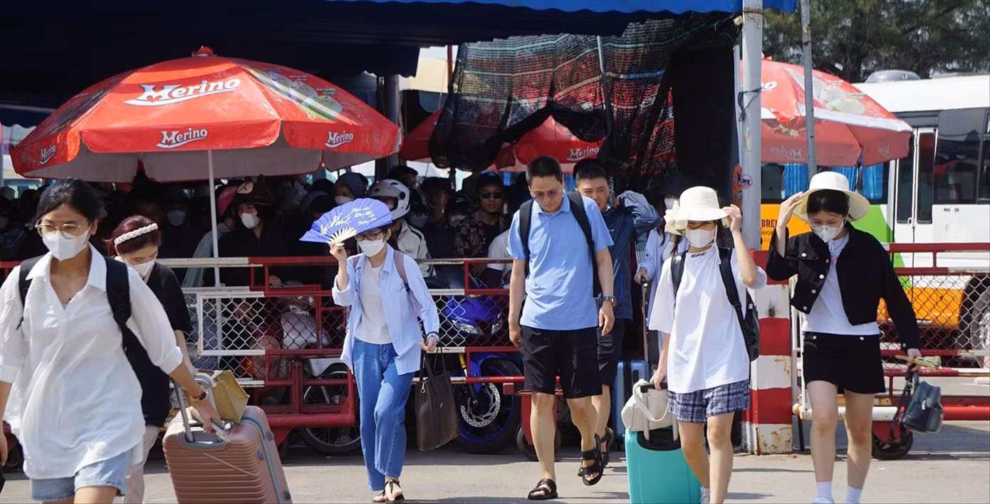 Du khách vạ vật vì cảnh ùn tắc cục bộ tại đường dẫn ra bến phà Cái Viềng. Ảnh: Nguyễn Hoàn