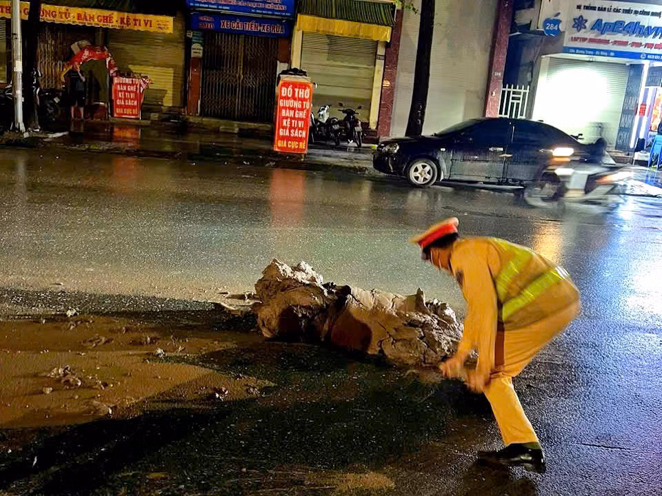 Lực lượng CSGT cảnh báo, phối hợp thu dọn đất bảo đảm an toàn giao thông.