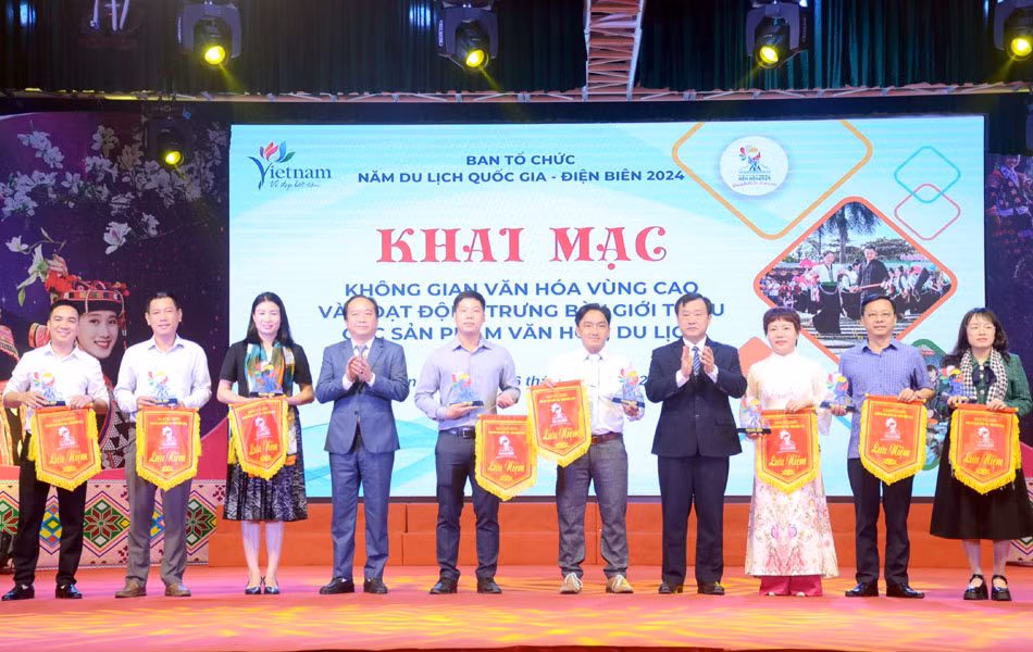 Phó Chủ tịch UBND tỉnh Điện Biên Vừ A Bằng trao cờ lưu niệm cho các đoàn tham gia trưng bày, giới thiệu văn hóa, du lịch.