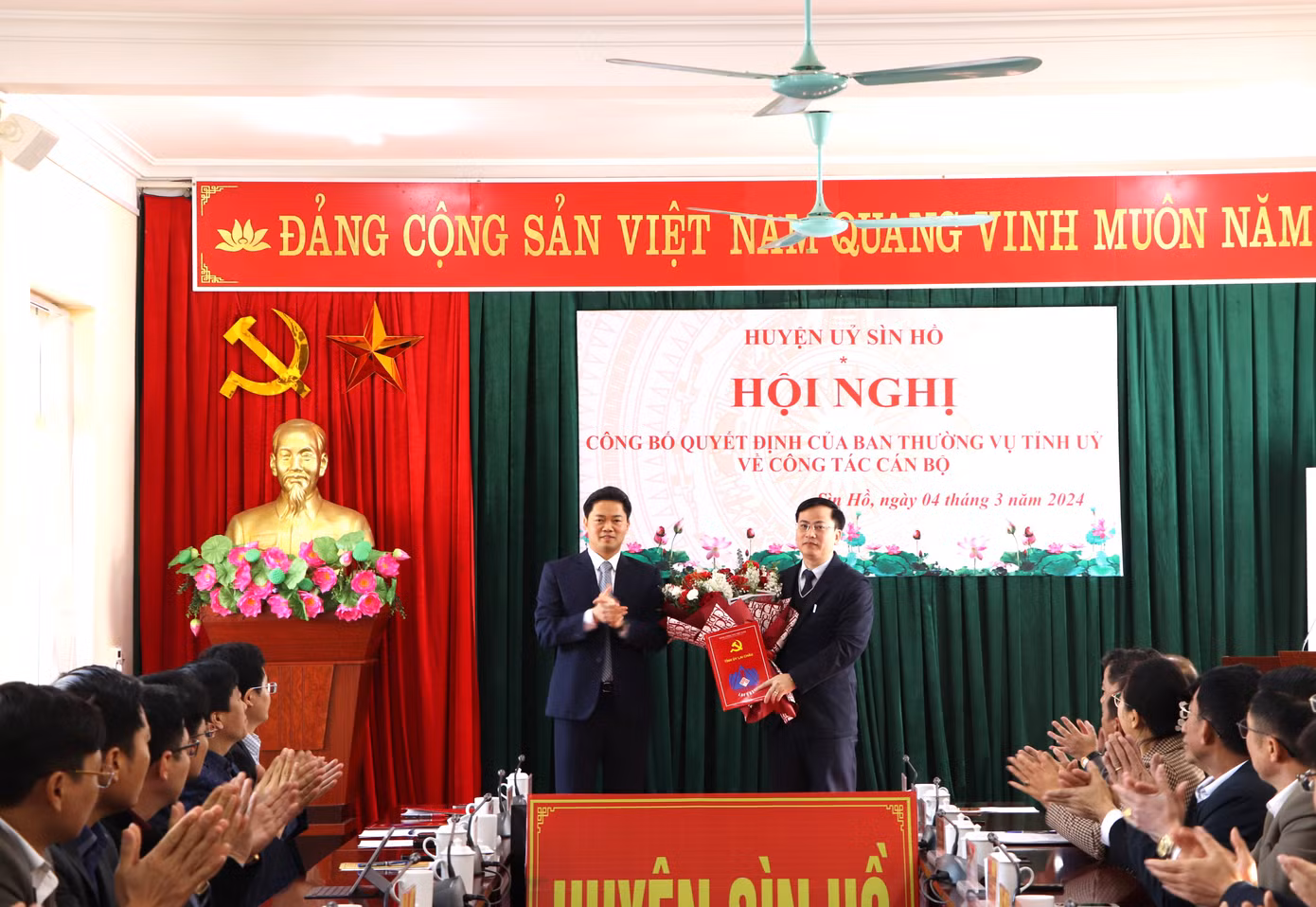 Phó Bí thư Thường trực Tỉnh ủy Lai Châu Vũ Mạnh Hà trao Quyết định và tặng hoa chúc mừng tân Phó Bí thư Huyện ủy Sìn Hồ Trần Văn Sứng.