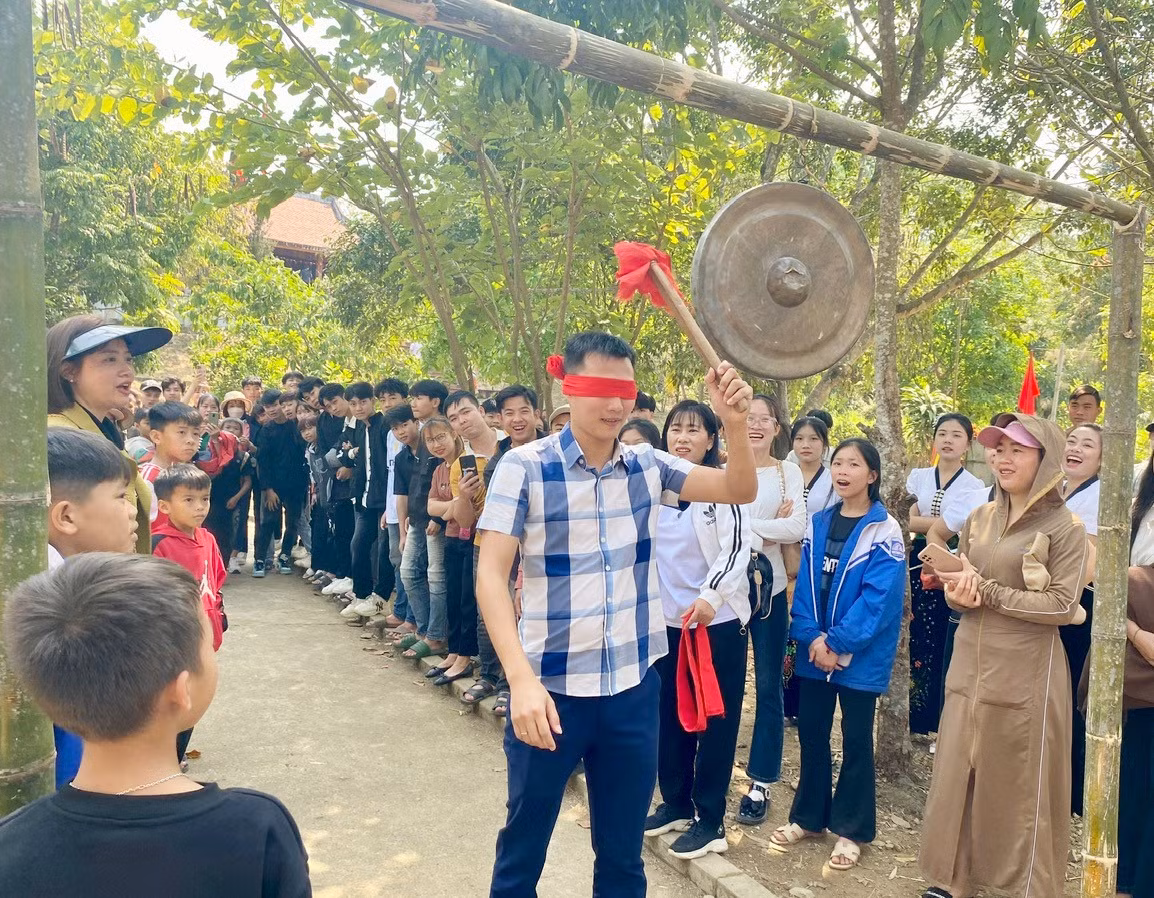 Du khách tham gia trò bịt mắt đánh chiêng.