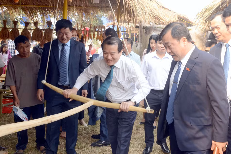 Các đại biểu trải nghiệm xay ngô truyền thống tại không gian văn hóa vùng cao.