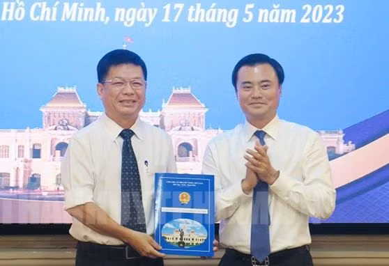 Phó Chủ tịch UBND TPHCM Bùi Xuân Cường trao quyết định cho ông Nguyễn Tương Minh (bìa trái). Ảnh: Thành ủy TPHCM.