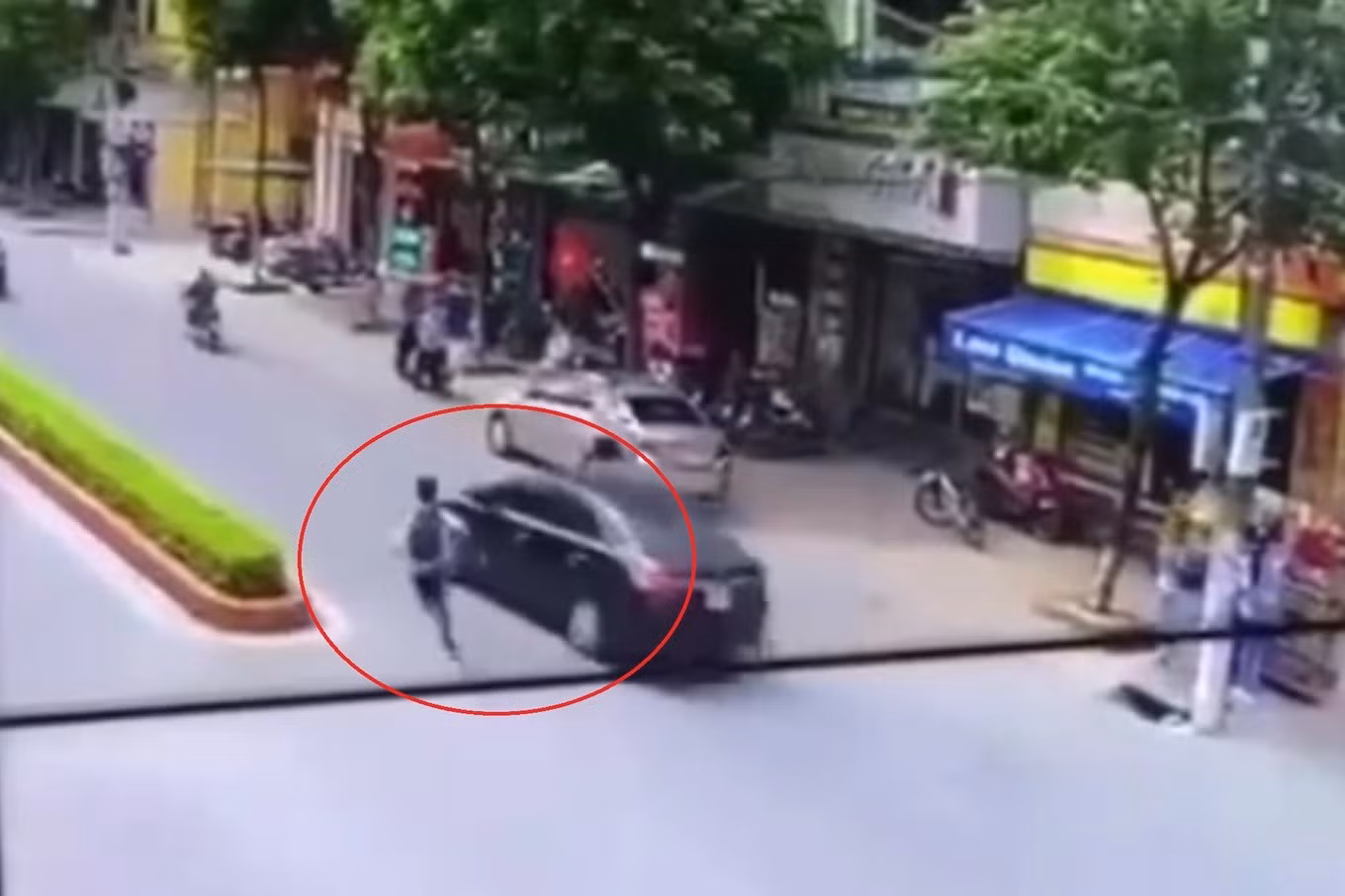 Hình ảnh cháu học sinh chạy bộ song song với chiếc ô tô rồi tạt đầu xe khiến tai nạn xảy ra (Ảnh: Cắt từ clip).