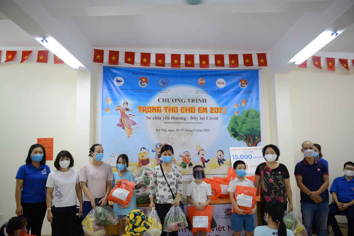 Đại diện Ban tổ chức chương trình tặng quà cho các em thiếu nhi tại khu vực Ngã Tư Sở, Hà Nội