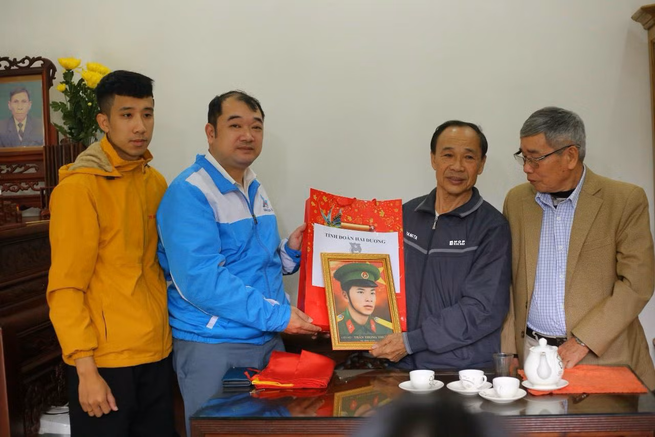 Đại diện Tỉnh Đoàn Hải Dương và nhóm Team Lee tặng quà Tết và ảnh phục dựng chân dung liệt sĩ tới gia đình liệt sĩ. Ảnh: TĐHD