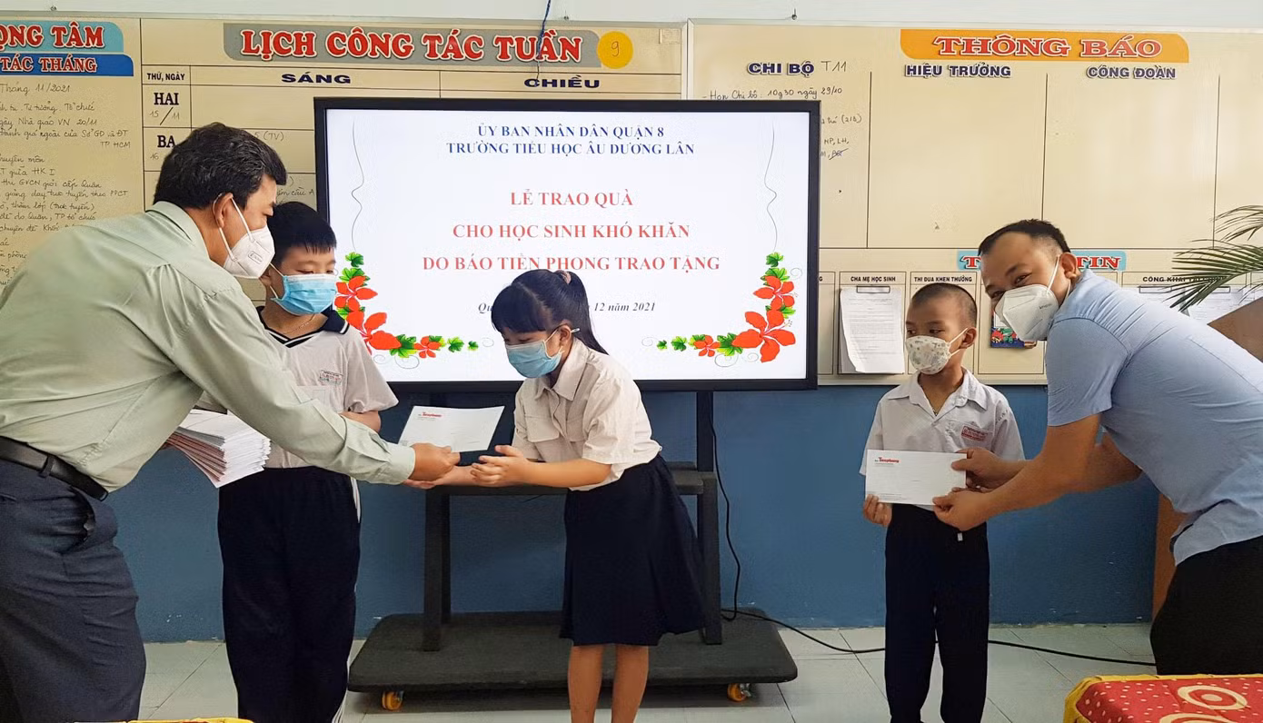 Đại diện nhà trường cùng báo Tiền Phong trao quà cho học sinh gặp khó khăn do dịch COVID-19
