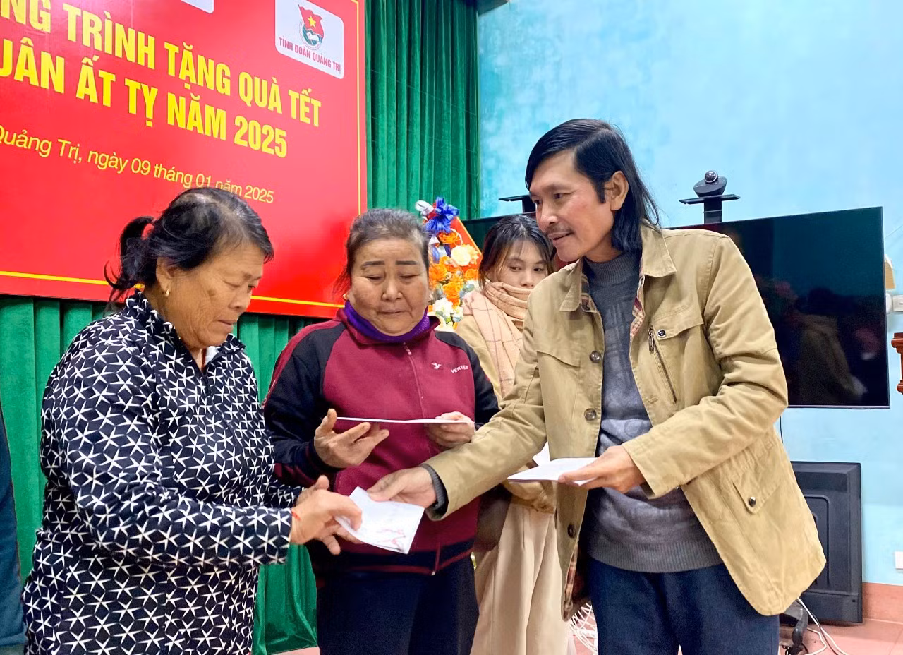 Nhà báo Hữu Thành, phóng viên báo Tiền Phong thường trú tại tỉnh Quảng Trị trao quà Tết cho bà con nghèo.
