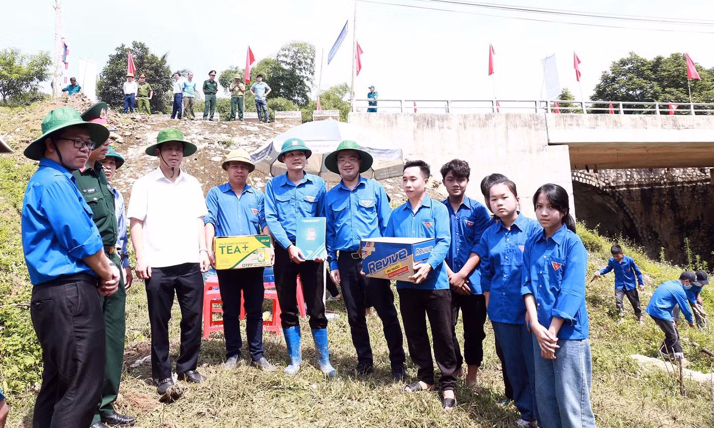 Anh Nguyễn Tường Lâm tặng quà đội hình thanh niên tình nguyện nạo vét kênh mương. Ảnh: Vương Bảo Anh