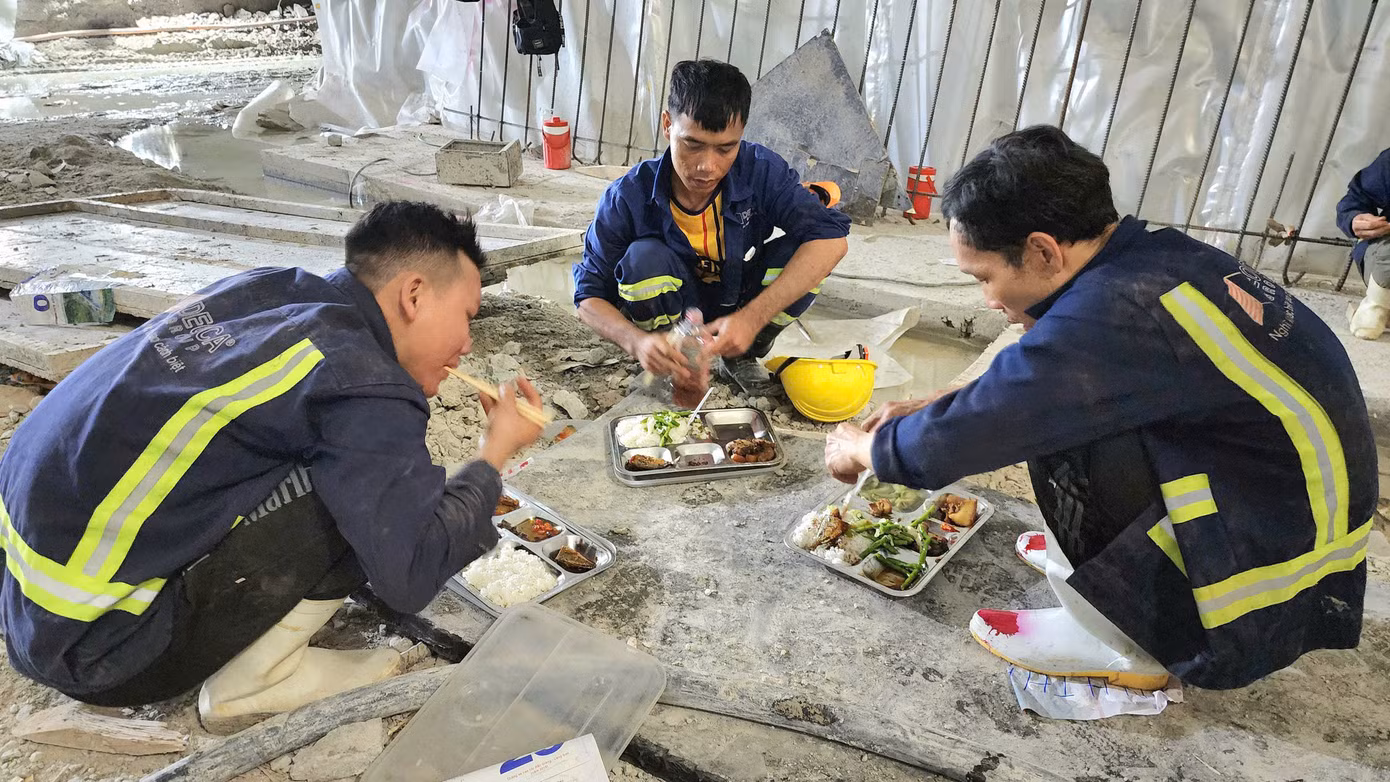 Các công nhân ăn vội bữa cơm trưa trong hầm số 3.