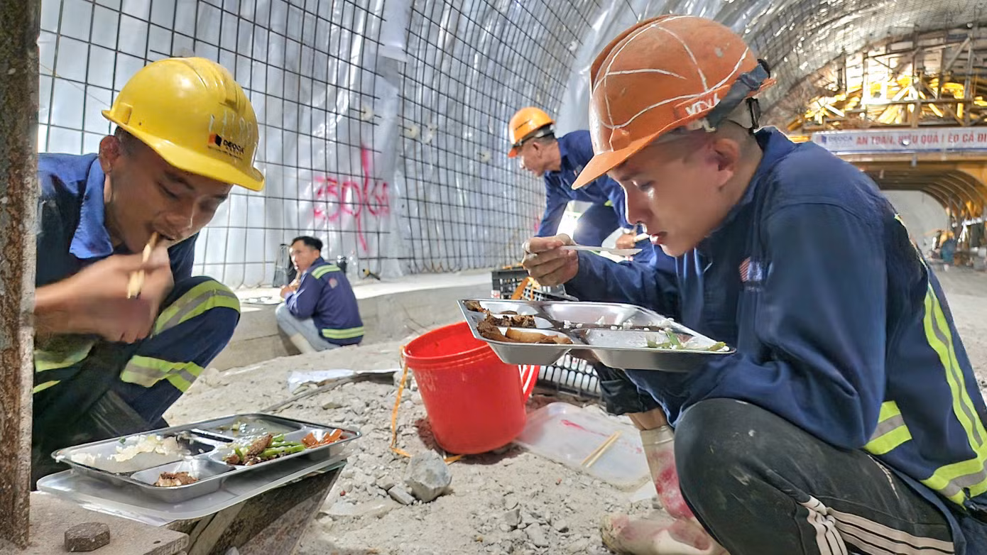 Các công nhân ăn vội bữa cơm trưa trong hầm số 3.
