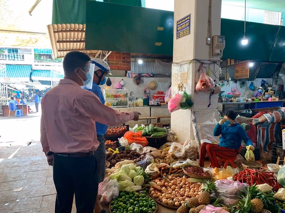 Lực lượng chức năng nhắc nhở người dân kéo cao khẩu trang. Ảnh: Nguyễn Ngọc