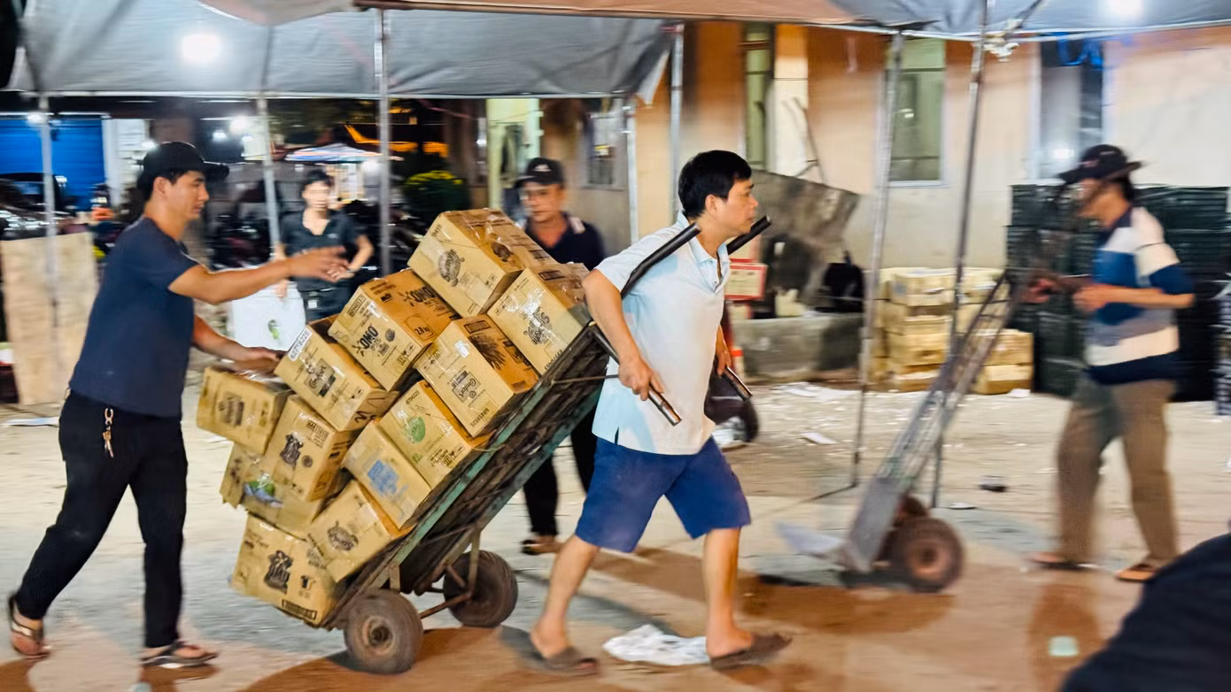 Anh Phạm Văn Anh (trú xã Nghĩa Hòa, huyện Tư Nghĩa, tỉnh Quảng Ngãi) chia sẻ, mỗi đêm kéo khoảng 300 thùng hàng đi giao khắp chợ, gần Tết tăng gấp 3-4 lần. Ảnh: Nguyễn Ngọc