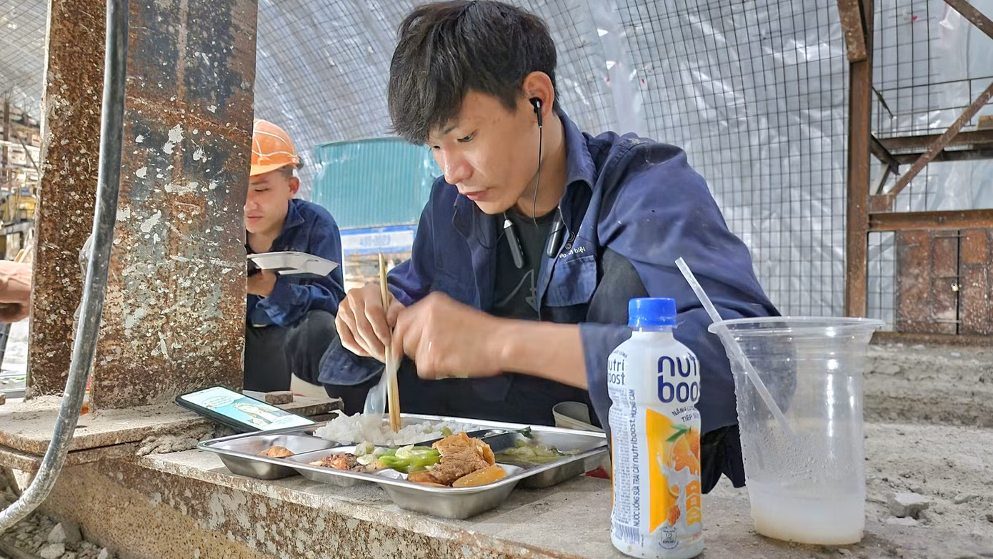 Các công nhân ăn vội bữa cơm trưa trong hầm số 3.