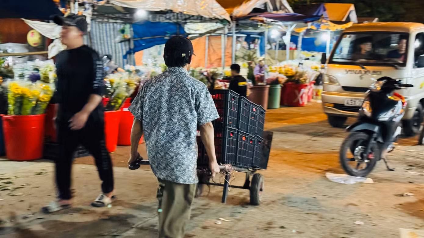 “Những ngày gần Tết, lượng hàng hóa về nhiều nên anh em làm nghề bốc vác ở chợ đầu mối phải làm việc liên tục và không màng tới giờ ngủ, khi nào hết hàng thì nghỉ. Mệt thì rất mệt nhưng bù lại có tiền để lo cho con cái có được một cái Tết ấm thì vất vả mấy cũng phải cố. Hôm nào chúng tôi cũng làm việc từ 21h cho đến 7h sáng hôm sau”, ông Phú nói. Ảnh: Nguyễn Ngọc