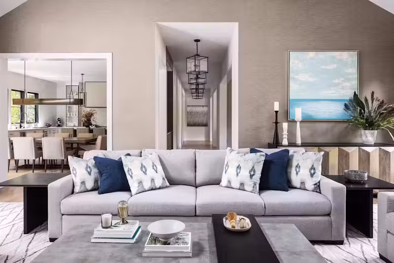 Điểm nhấn đáng chú ý trong không gian phòng khách là chiếc sofa dài, tạo sự thoải mái cho chủ nhà và khách khi vừa ngả lưng thư giãn vừa ngắm khung cảnh thiên nhiên. Không gian được bố trí cạnh khu vực bếp nướng ngoài trời, giúp việc kết nối bên trong và bên ngoài trở nên thuận tiện.