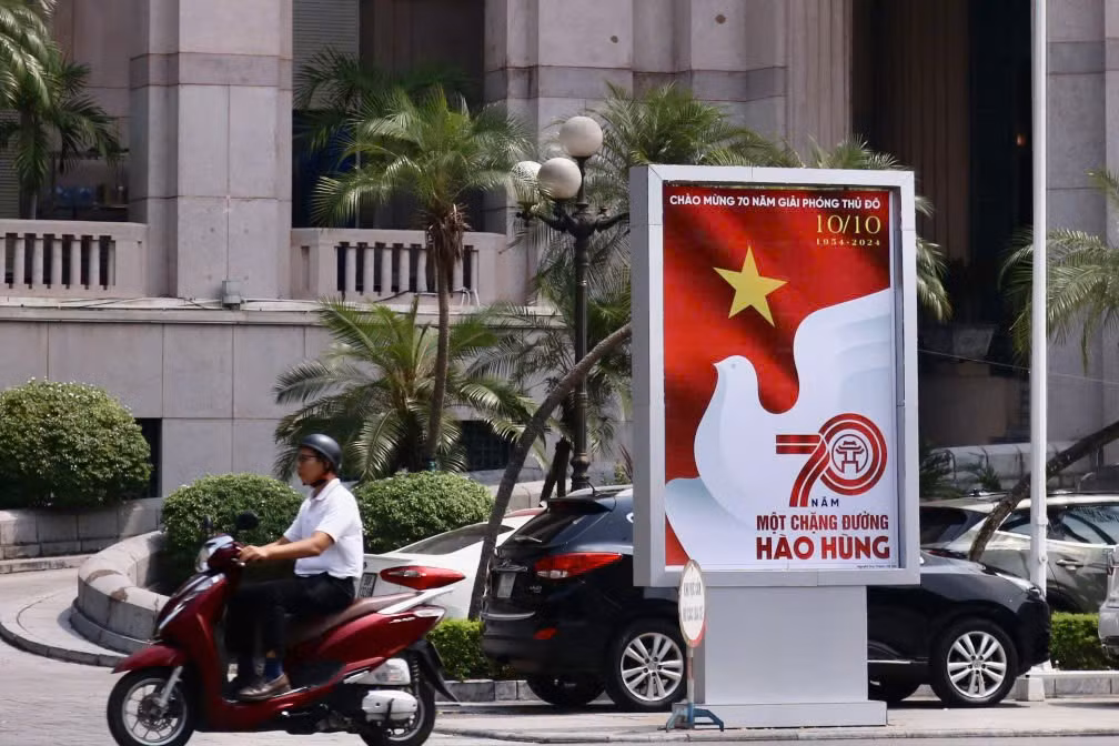 Đường phố rực rỡ sắc đỏ của cờ hoa và áp phích chào mừng.