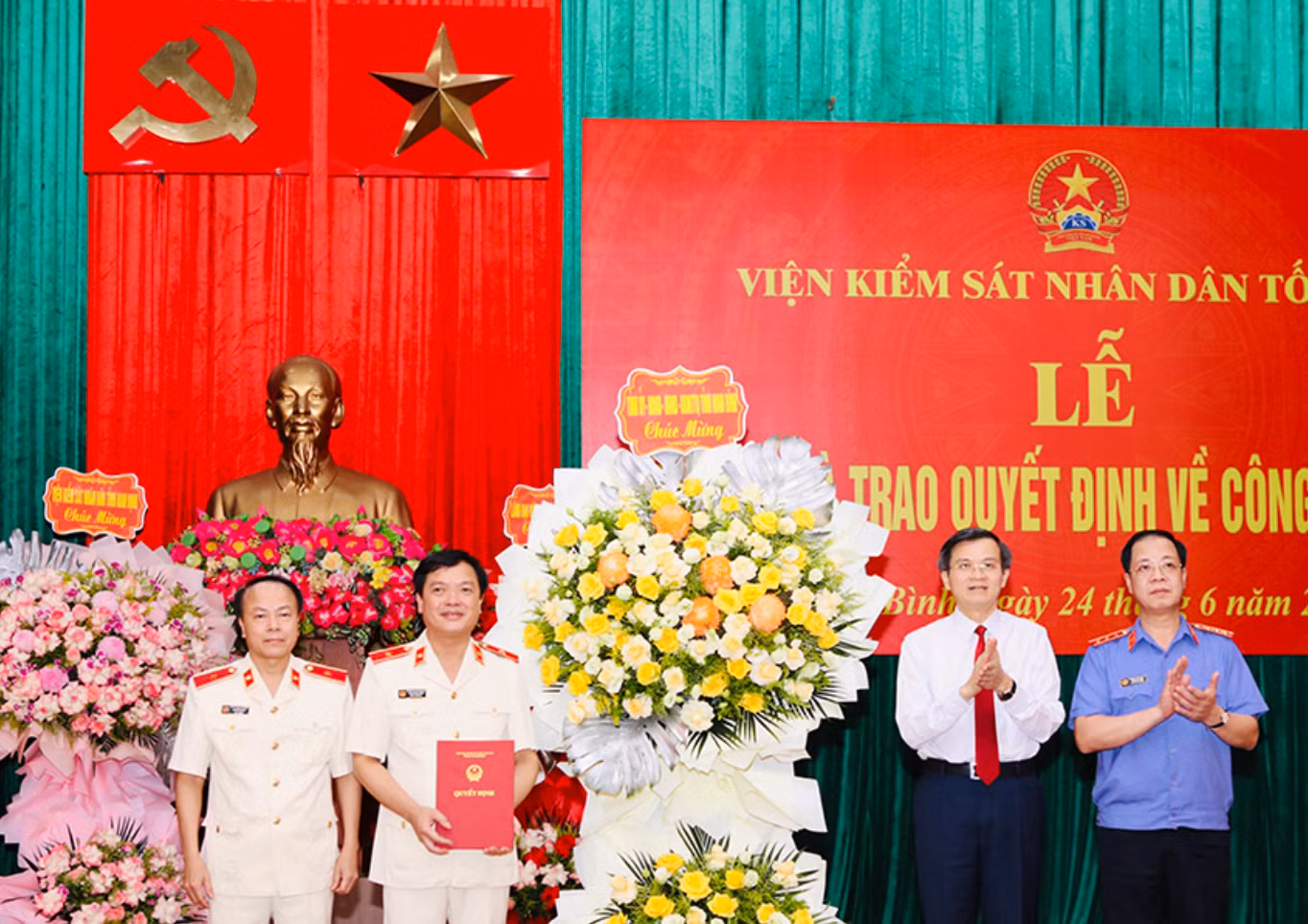 Đồng chí Bí thư Tỉnh ủy Đoàn Minh Huấn và đồng chí Trần Hải Quân, Phó Viện trưởng Viện Kiểm sát Nhân dân tối cao (phải) trao quyết định, tặng hoa chúc mừng đồng chí Phạm Ngọc Cảnh.