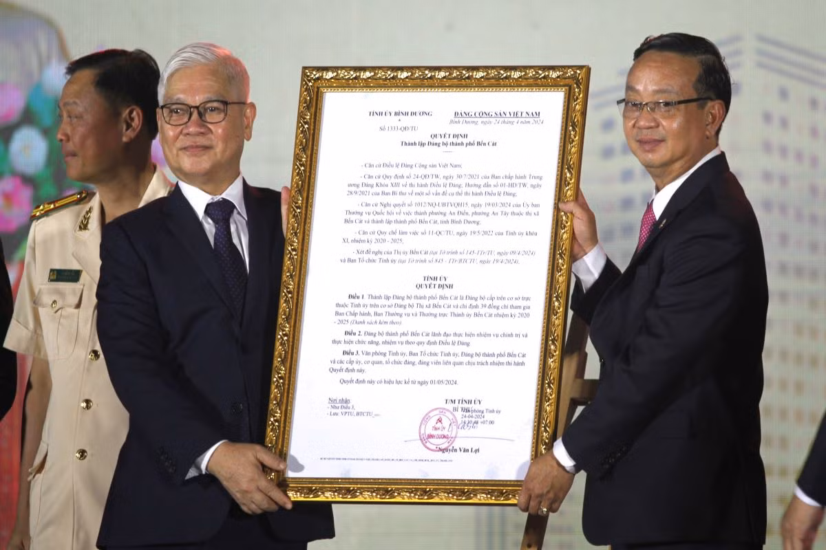 Bí thư Tỉnh ủy Bình Dương Nguyễn Văn Lợi (bìa trái) trao quyết định thành lập Đảng bộ thành phố Bến Cát