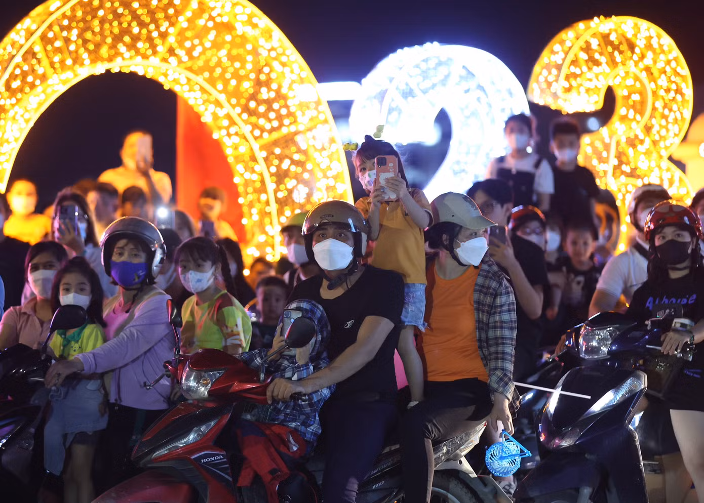 Một số gia đình chở theo con nhỏ, không quên đeo khẩu trang tại địa điểm đông người.