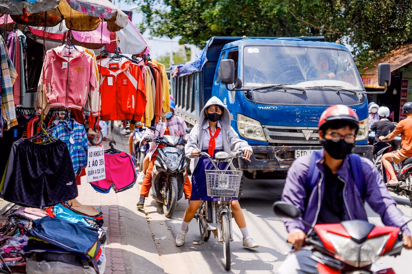 Một em học sinh vất vả len giữa dòng phương tiện.