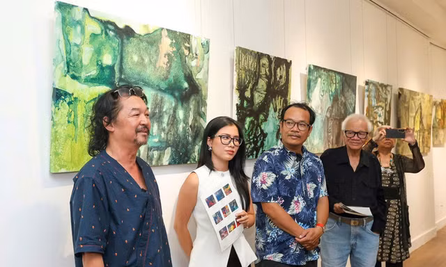 Nhà thơ, họa sĩ Huỳnh Lê Nhật Tấn (bìa trái) cùng bạn bè văn nghệ trong buổi khai mạc triển lãm
