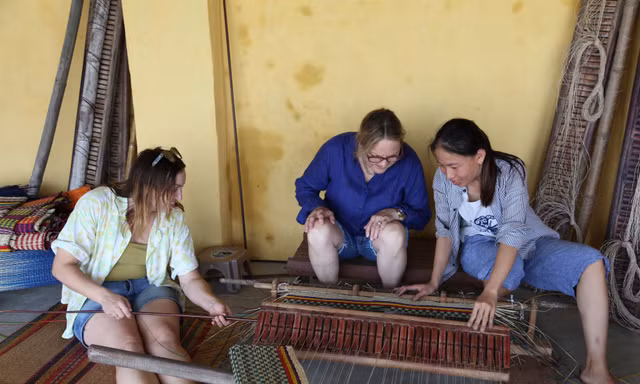 Du khách tập dệt chiếu dưới sự hướng dẫn của chị CôngẢnh: Giang Thanh