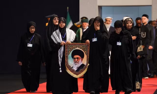 Phụ nữ bày tỏ lòng kính trọng khi đi đến gần quan tài của cố Lãnh đạo tối cao Iran Ali Khamenei và các thành viên gia đình ông, vào ngày các đại biểu quốc tế tham gia lễ tiễn biệt ông Khamenei, tại Đại sảnh Imam Khomeini ở thủ đô Tehran của Iran, ngày 3/7/2026. Ảnh: Reuters.