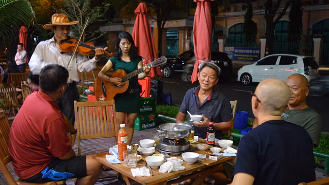 Anh Minh, chị My đến tận bàn chơi đàn khi được yêu cầu. Ảnh: N.B