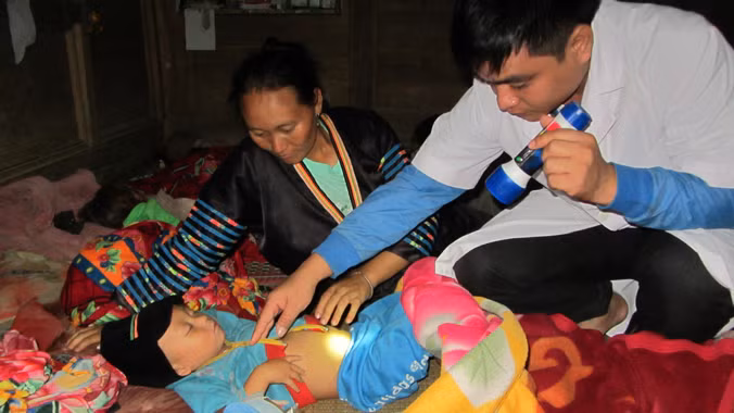 Chăm sóc bệnh nhi tại bệnh viện dã chiến lập ở điểm trường khối tiểu học Piềng Cọc, huyện Tương Dương (Nghệ An). Ảnh: Nhật Lân