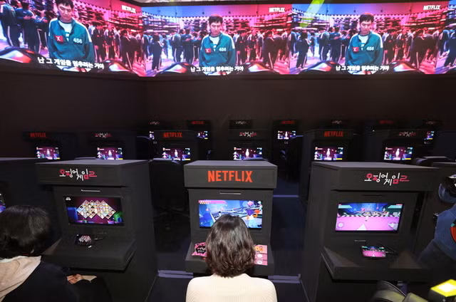 Các phóng viên đang trải nghiệm trò chơi Squid Game tại khu vực trải nghiệm loạt phim Squid Game Season 2 của Netflix được tổ chức tại Dongdaemun Design Plaza (DDP) ở Jung Gu, Seoul. Theo phân tích của Ampere, một công ty phân tích thị trường truyền thông toàn cầu, nội dung Hàn Quốc trên Netflix, bao gồm phim truyền hình, phim điện ảnh và chương trình giải trí Hàn Quốc, đang được ưa chuộng trên toàn cầu, sau nội dung Hollywood của Mỹ. Hàn Quốc hiện chiếm 85 (17%) trong số 500 chương trình và phim không phải của Mỹ phổ biến nhất trên Netflix. Nội dung Hàn Quốc đóng vai trò quan trọng trong thành công toàn cầu của Netflix, thúc đẩy lượng người xem ổn định với những bộ phim ăn khách như Squid Game và Kingdom. Phân tích đã chỉ ra rằng bí quyết thành công của nội dung Hàn Quốc nằm ở chiến lược cấp phép và sản xuất nội dung lâu đời. Hơn một nửa số phim Hàn Quốc trong Top 100 trên Netflix vào nửa cuối năm ngoái là tác phẩm gốc, 31% là phim độc quyền của Netflix và phần lớn trong số đó được cung cấp bởi CJ ENM, một công ty nội dung lớn của Hàn Quốc. Tận dụng hiện tượng 'Làn sóng Hàn Quốc toàn cầu', các công ty nội dung Hàn Quốc quyết định các khoản đầu tư quy mô lớn vào nội dung Hàn Quốc của Netflix và hợp tác mở rộng với các hãng phim ở nước ngoài để giúp duy trì sự bùng nổ này trong tương lai, ít nhất là đến năm 2028.