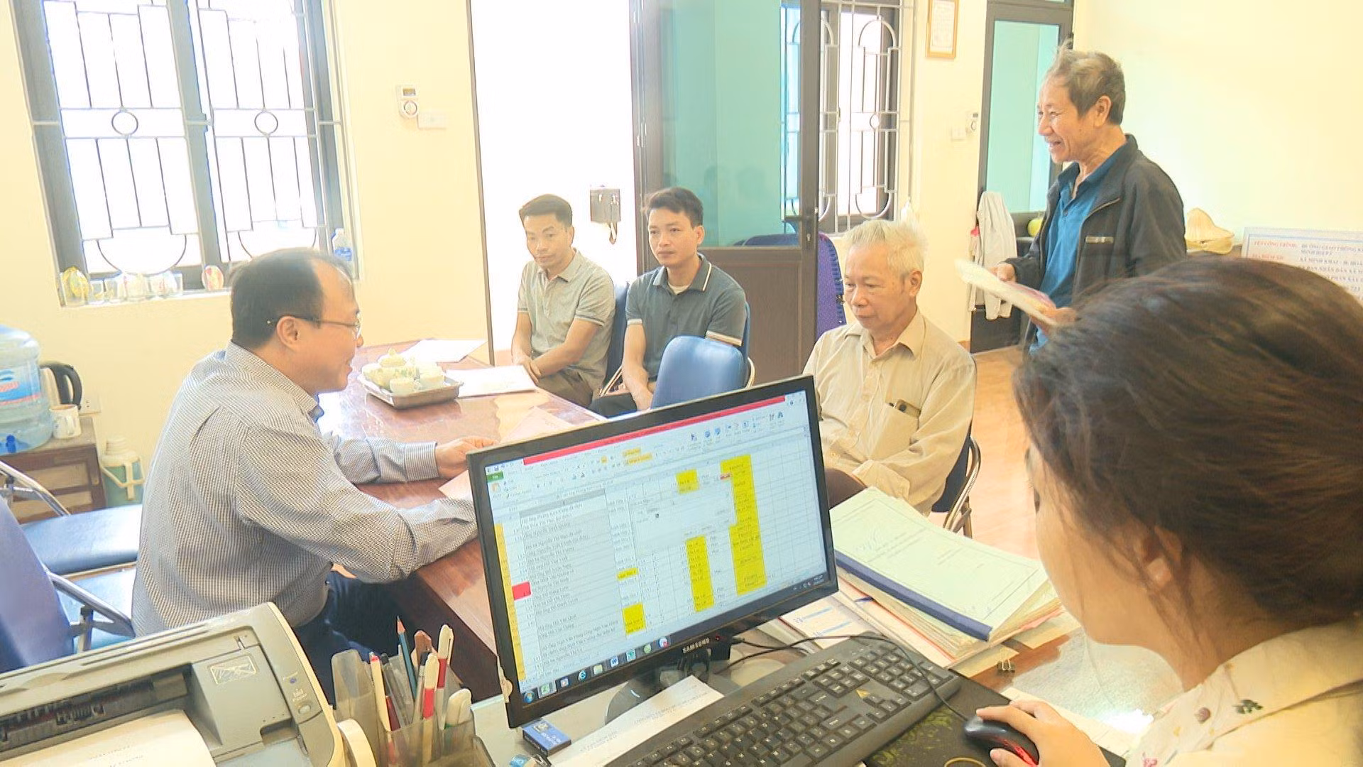 Ảnh 1: Người dân được cán bộ xã hướng dẫn chi tiết các thủ tục liên quan đến di dời mộ phần. Ảnh 2: Chính quyền địa phương cùng người dân đo đạc, cắm mốc tại xã Song Phương, huyện Hoài Đức