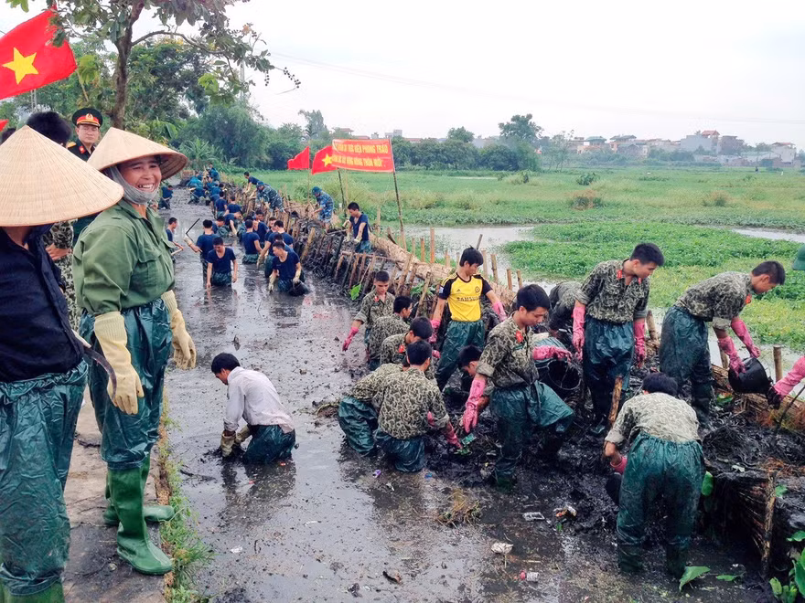 Bộ đội Đặc công tham gia giúp dân làm sạch kênh mương, cải tạo môi trường trên địa bàn huyện Thanh Trì, Hà Nội. Ảnh: Hồng Lương