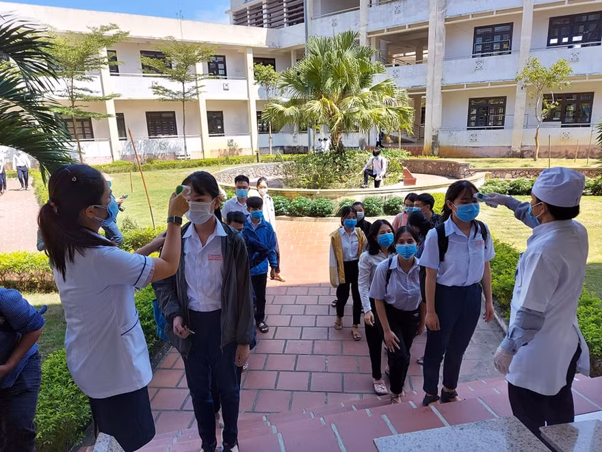 Đo thân nhiệt cho thí sinh trước khi vào phòng thi tốt nghiệp. ảnh H. Văn