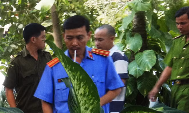 Lê Sơn Tùng (đầu trọc) đang dựng lại hiện trường vụ cướp tại nhà bà Trần Hồng Sa. 
